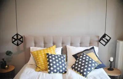 a bedroom with a bed with pillows on it at 3D Szlak 77 Apartament in Kraków