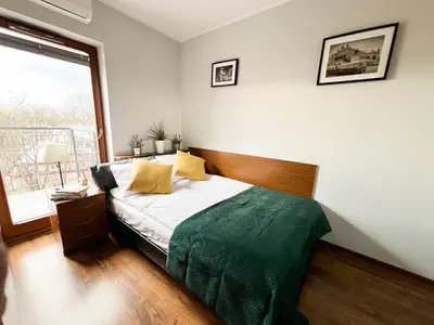a bedroom with a bed and a large window at 3D Szlak 77 Apartament in Kraków