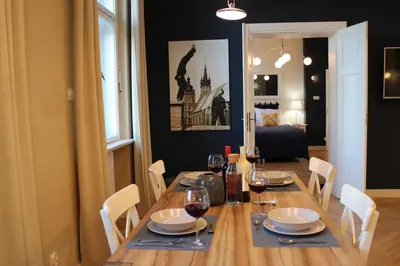 a dining room table with chairs and wine glasses at Dominican Square by Hashtag Apartments in Kraków