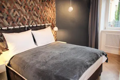 a bedroom with a large bed with a wooden headboard at Dominican Square by Hashtag Apartments in Kraków