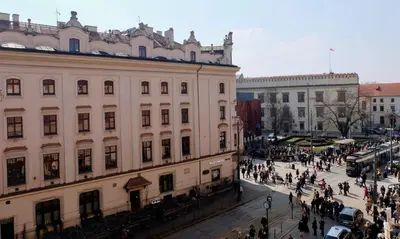 a group of people walking on a street in a city at Dominican Square by Hashtag Apartments in Kraków