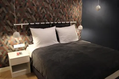 a bedroom with a large bed with a wooden wall at Dominican Square by Hashtag Apartments in Kraków
