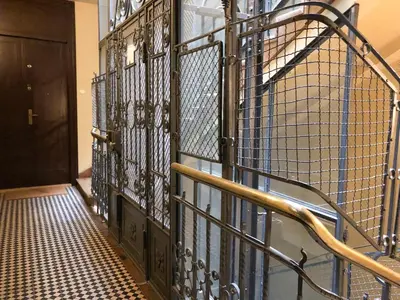 a wrought iron staircase in a hallway with a door at Dominican Square by Hashtag Apartments in Kraków