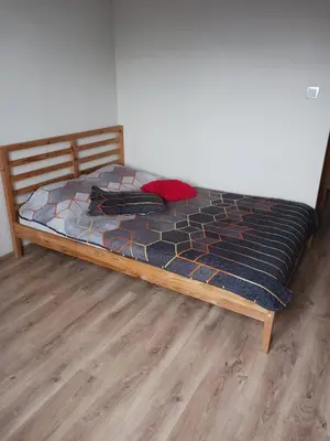 a bed with a wooden frame in a room at Apartamenty Marco 3 przy Dworcu-Stare Miasto-Super Wi Fi in Kraków
