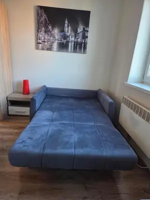 a blue couch in a room with a picture on the wall at Apartamenty Marco 3 przy Dworcu-Stare Miasto-Super Wi Fi in Kraków