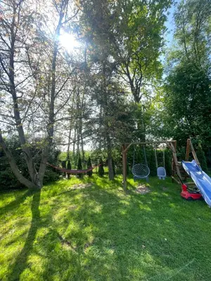 a backyard with a swing set and trees at Dom pod orzechem in Spytkowice