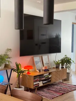 a living room with a large television on a wall at Dom pod orzechem in Spytkowice