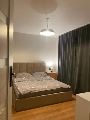 a bed in a bedroom with a black curtain at Dom pod orzechem in Spytkowice