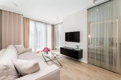 an open balcony with glass doors and a living room at Glossy Apart M54 in Kraków