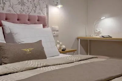 a bedroom with a bed with a pink head board at Bentis Luxury Apartments in Kraków