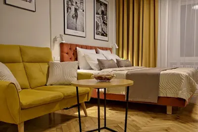 a bedroom with a bed and a couch and a table at Bentis Luxury Apartments in Kraków