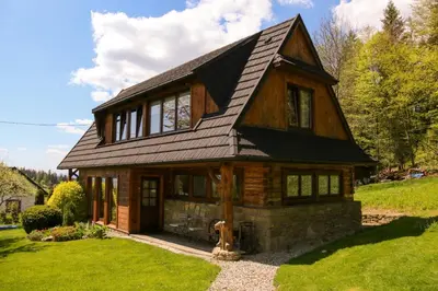 a wooden house with a gambrel roof at Buflaczanka in Nowy Targ