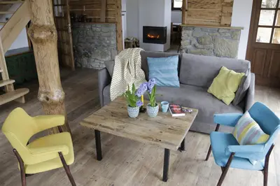 a living room with a couch and a table and chairs at Buflaczanka in Nowy Targ
