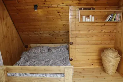 a bed in the corner of a wooden cabin at Buflaczanka in Nowy Targ