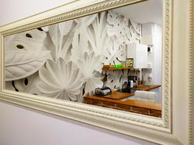 a mirror in a gold frame hanging on a wall at Apartament Starowiślna in Kraków