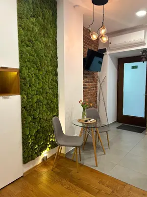 a green wall in a living room with a table and chairs at Apartament Starowiślna in Kraków