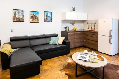 a living room with a black couch and a table at Exclusive Royal Apartments in Kraków