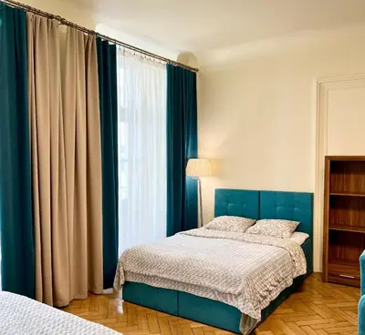 a bedroom with a blue bed and a window at Apartamenty i Studia HERBARIUM in Kraków