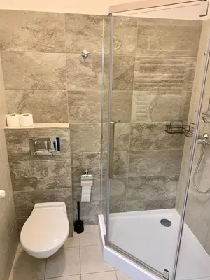 a bathroom with a toilet and a glass shower at Apartamenty i Studia HERBARIUM in Kraków