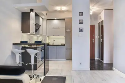 a kitchen with a counter and some stools in it at D&A Apartments Old Town in Kraków