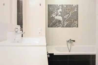 a bathroom with a sink and a painting on the wall at D&A Apartments Old Town in Kraków