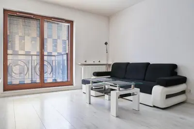 a living room with a black couch and a table at D&A Apartments Old Town in Kraków