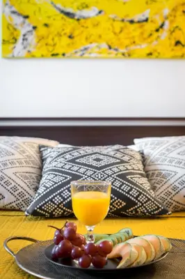 a glass of orange juice and grapes on a table at Cichy apartament obok Wawelu Tarłowska in Kraków