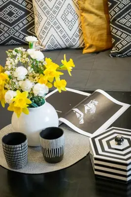 a table topped with a vase with flowers and pamphlets at Cichy apartament obok Wawelu Tarłowska in Kraków