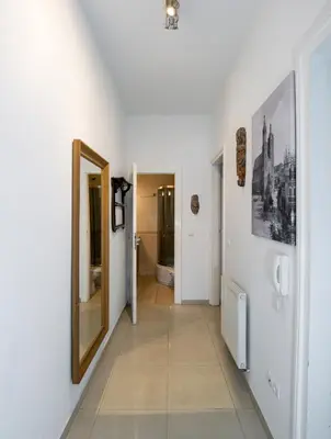 a hallway with white walls and a mirror on the wall at Cichy apartament obok Wawelu Tarłowska in Kraków