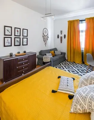 a bedroom with a yellow bed and a couch at Cichy apartament obok Wawelu Tarłowska in Kraków