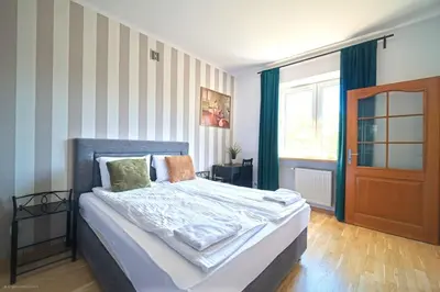 a bedroom with a bed and a window and a door at Spacious Apt by Airport Train Old Town in Kraków