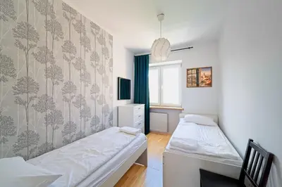 a bedroom with two beds and a window at Spacious Apt by Airport Train Old Town in Kraków