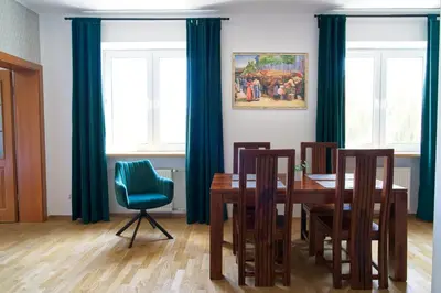 a dining room with a wooden table and blue curtains at Spacious Apt by Airport Train Old Town in Kraków