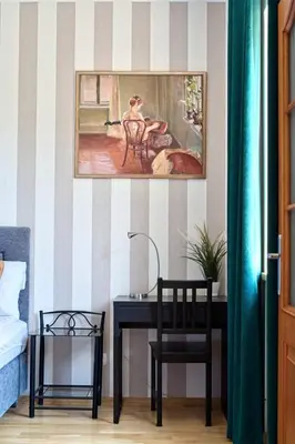 a bedroom with a desk and a painting on the wall at Spacious Apt by Airport Train Old Town in Kraków