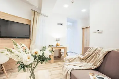 a living room with a couch and a vase of flowers at Way2Stay Bosacka in Kraków