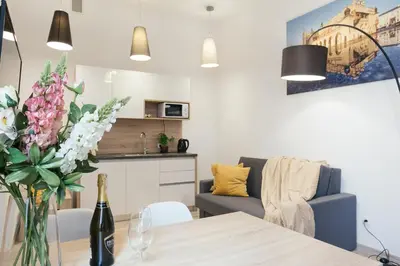 a living room with a table with a vase of flowers at Way2Stay Bosacka in Kraków