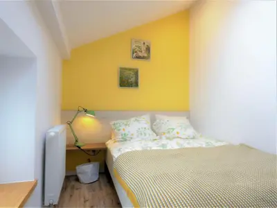 a bedroom with a bed and a yellow wall at Way2Stay Bosacka in Kraków