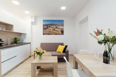 a kitchen and living room with a table and a couch at Way2Stay Bosacka in Kraków