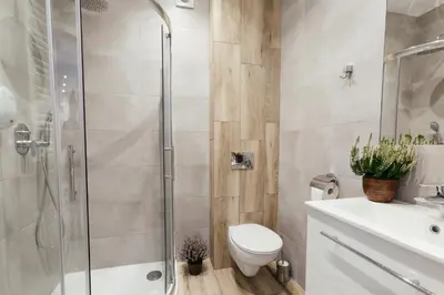 a bathroom with a shower and a toilet and a sink at Way2Stay Bosacka in Kraków