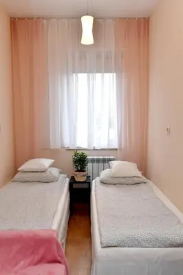 two beds in a room with a window at Zator Apartamenty Weekend in Zator