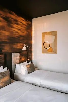 a bedroom with two beds and a painting on the wall at Poziom 511 Jura Wellness Hotel & Spa in Ogrodzieniec