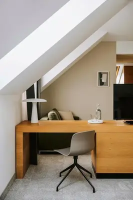 a desk with a chair and a television in a room at Poziom 511 Jura Wellness Hotel & Spa in Ogrodzieniec