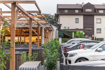 a row of parked cars in a parking lot at Old Tree Village & Restaurant in Oświęcim