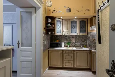 a kitchen with wooden cabinets and a white door at Anno Domini Apartment by Cozyplace in Kraków