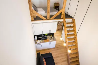 a room with a staircase leading up to a loft at Cracow Best Location Apartment by Cozyplace in Kraków