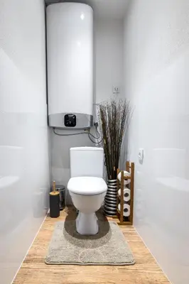 a bathroom with a white toilet and a rug at Cracow Best Location Apartment by Cozyplace in Kraków