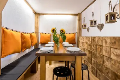 a dining room with a table and yellow cushions at Cracow Best Location Apartment by Cozyplace in Kraków