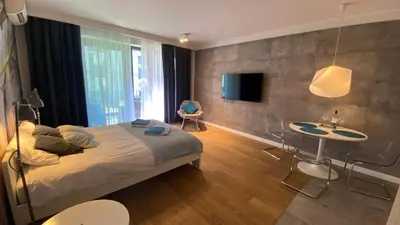 a bedroom with a bed and a table and a tv at Apartment in the Gantry Hall - W19 in Kraków