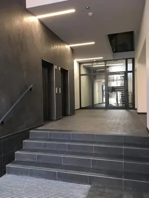 an empty lobby with stairs in an office building at Apartment in the Gantry Hall - W19 in Kraków