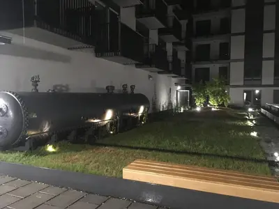a train sitting on the grass in front of a building at Apartment in the Gantry Hall - W19 in Kraków